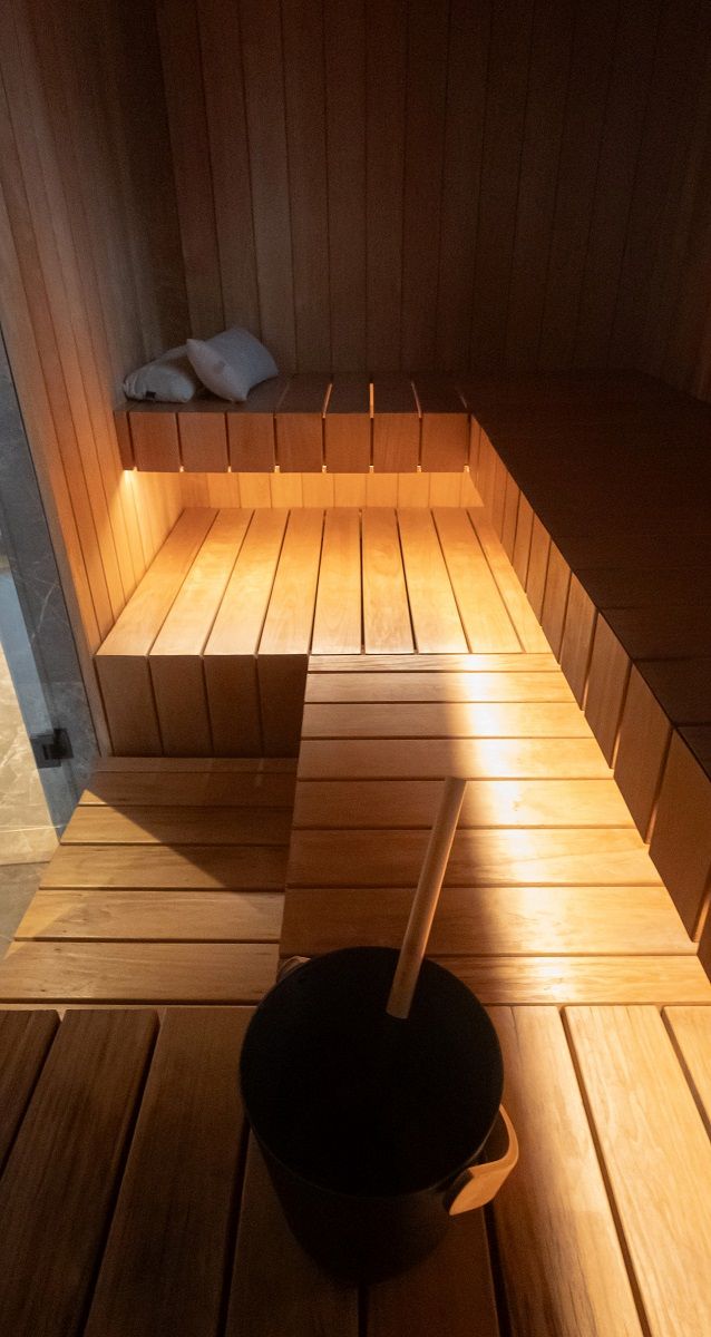 A 7.2 W/m warm-toned LED strip in aluminium profile mounted on the underside of a sauna seat.